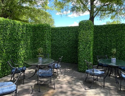 Faux jasmine hedge walls forming a private patio lounge at an outdoor event