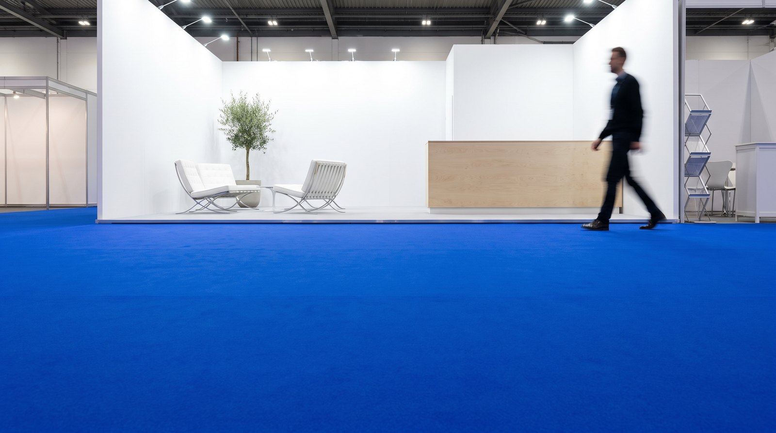 Royal blue flat event carpet laid tight across an open exhibition stand