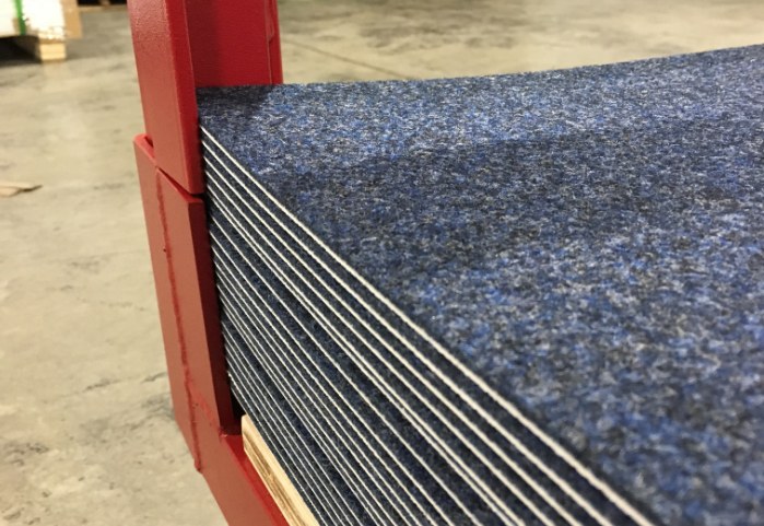 Close-up of blue gym floor cover tiles stacked on a storage cart